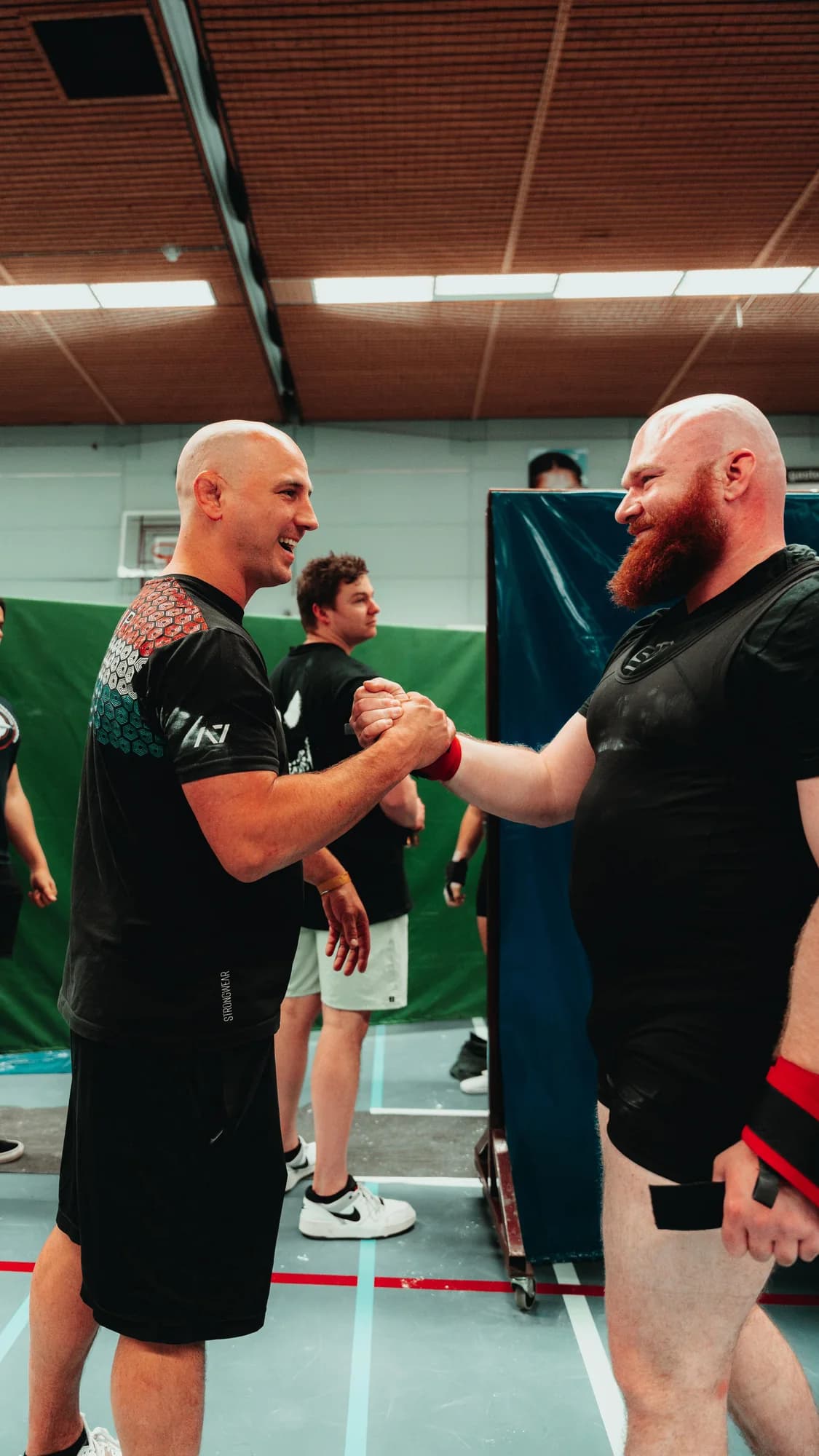 Bram Strik feliciteert een powerlifter na zijn wedstrijdprestatie