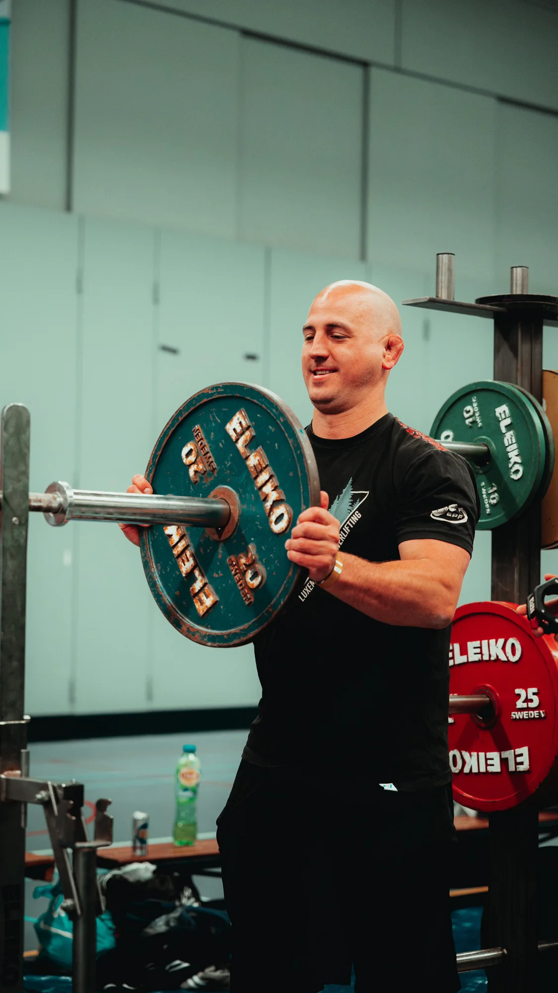 Bram Strik laadt gewichten tijdens een powerliftingwedstrijd
