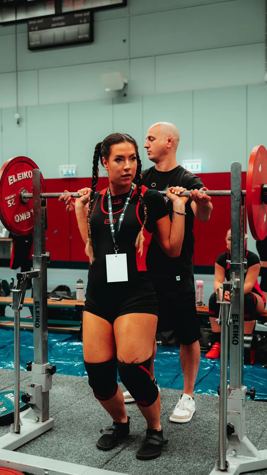 Bram Strik begeleidt een atlete bij haar squat